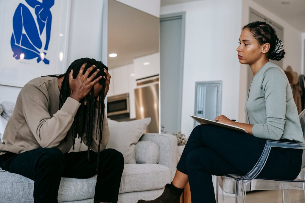 A man and a therapist in a counseling session, discussing mental health concerns.