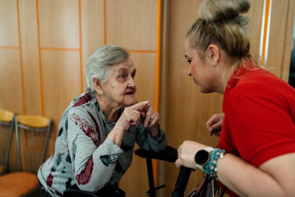 Mastering the First Impression: Your intriguing post title goes here Elderly woman and caregiver in conversation inside a room in Karviná, Česko.